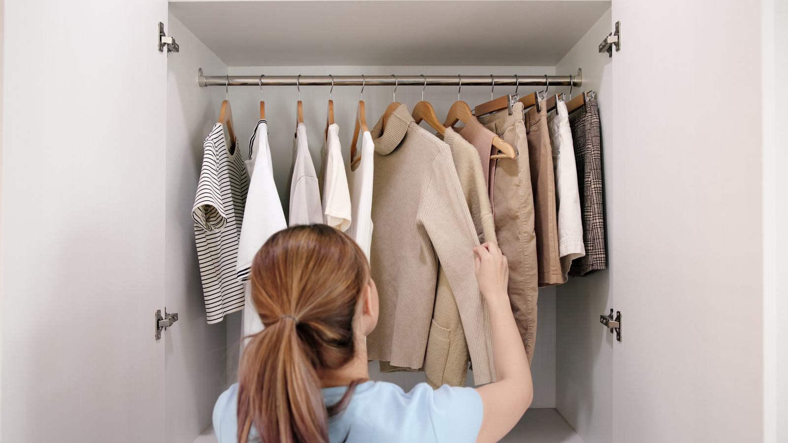 Woman looking in wardrobe of clothes