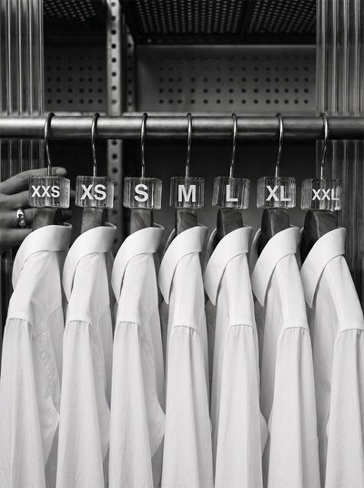 shirts in different sizes hanging on rack